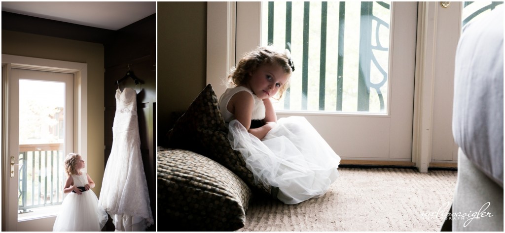 Flower girl gazes up at bride's gown by Topeka wedding photographer Melissa Sigler