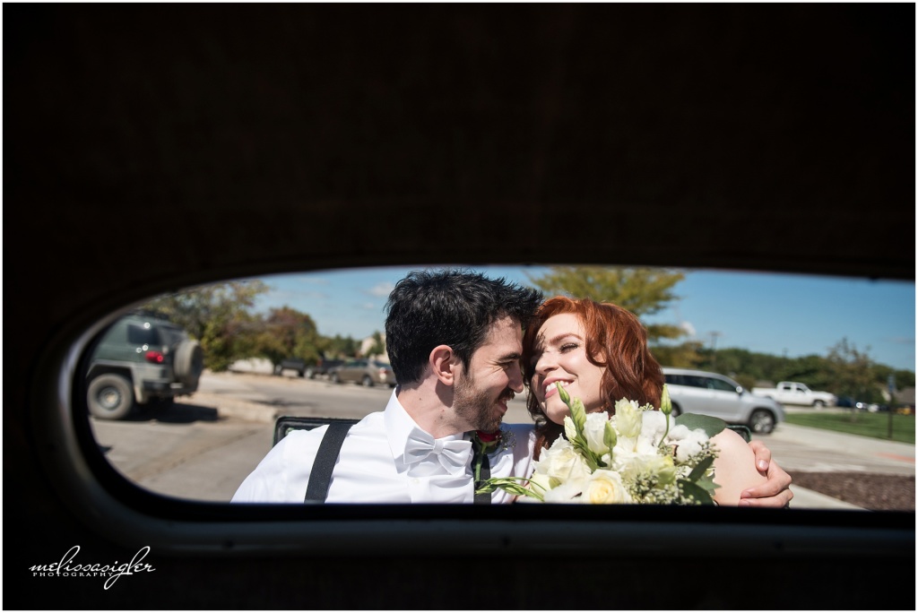 Bride and groom drive off in old car