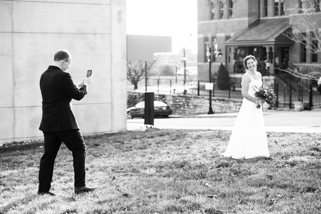 Groom taking a photo of bride