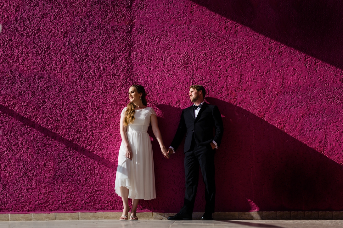 beach wedding couple against pink wall