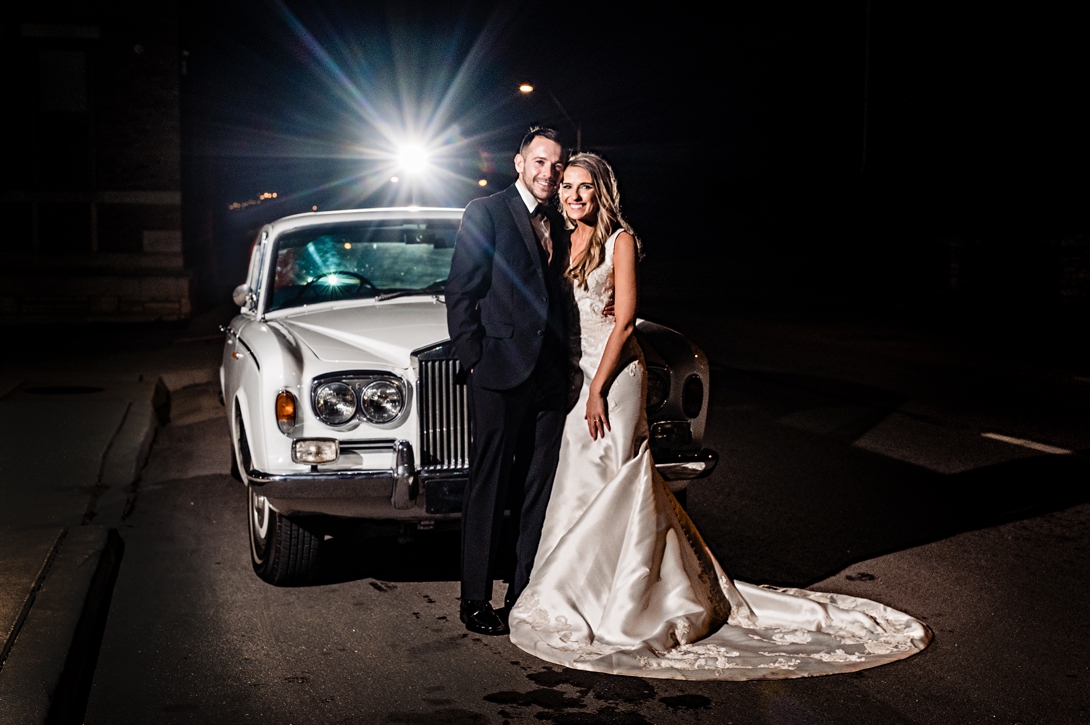 Bride and groom in front of Bentley